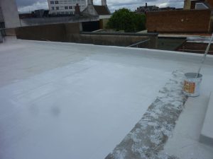 Work in progress on a flat roof recoating project in Neath, Swansea